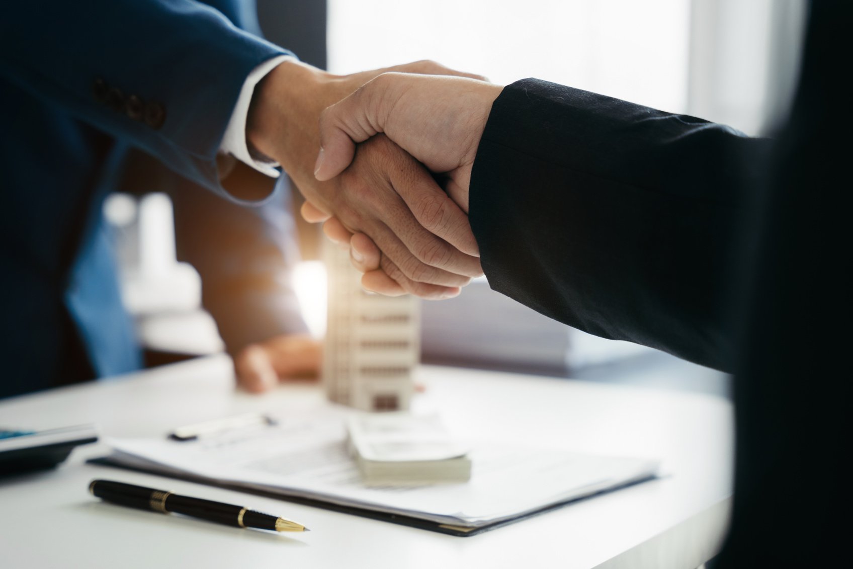 Close up two men shake hands at office negotiations. Making deal sign, conclude contract, formal greeting, strike bargain. Successful negotiations, insurance home loan concept.